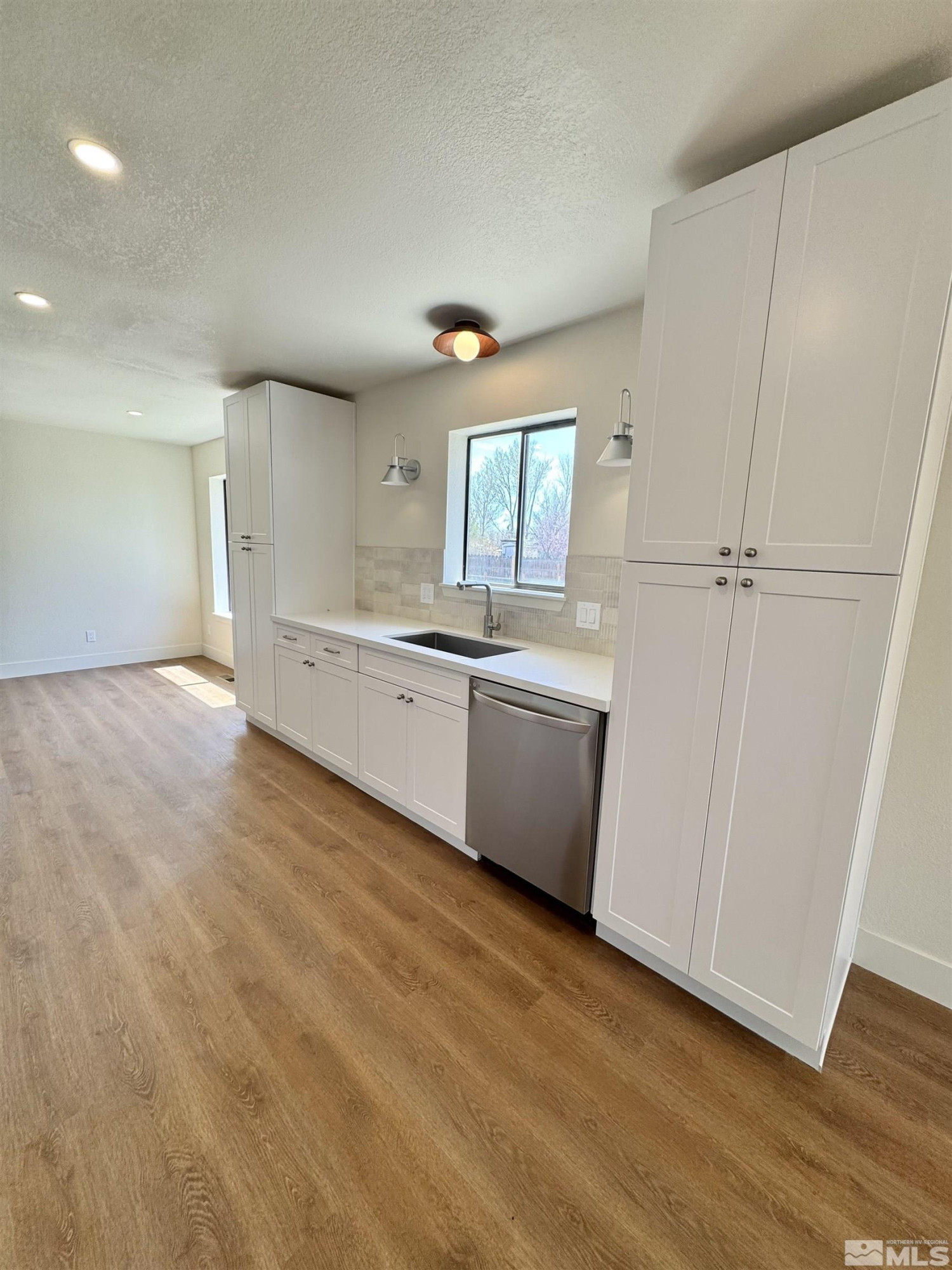 3003 Alcorn Road Fallon, NV 89406 - Photo 8 of 17 a view of a kitchen with white cabinets and wooden floor