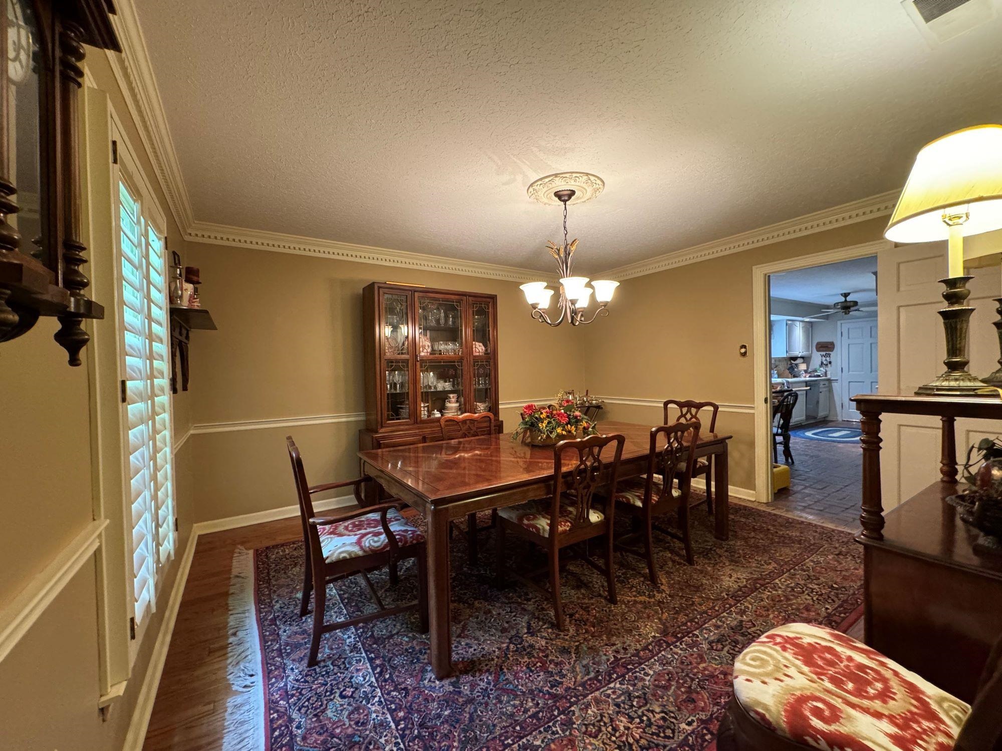 2695 Brook Bridge Cove Germantown, TN 38138 - Photo 4 of 40 Large dining room with chairrail and dental molding, plantation shutters, and hardwood floors.
