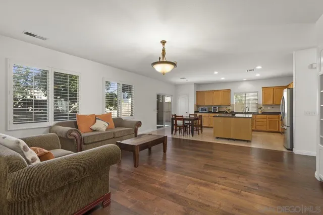 a living room with furniture kitchen view and a flat screen tv