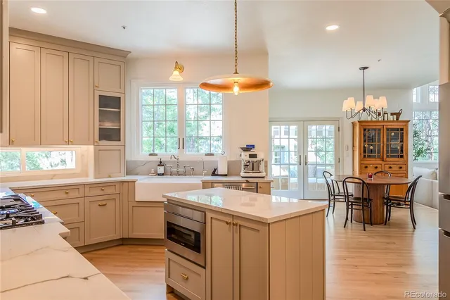 a kitchen with a stove a sink a kitchen island with a dining table and chairs