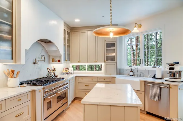 a kitchen with stainless steel appliances granite countertop a sink stove and cabinets