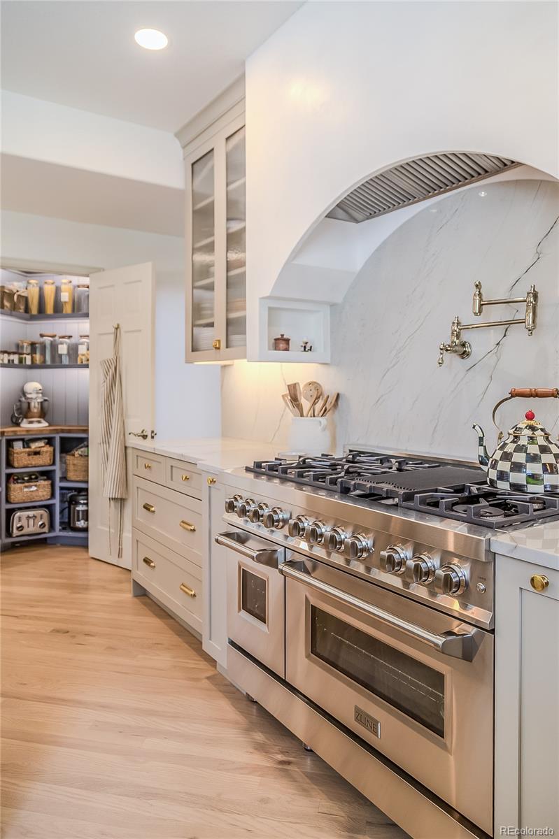 475 Silbrico Way Castle Rock, CO 80108 - Photo 26 of 50 a kitchen with granite countertop a stove and a wooden cabinets