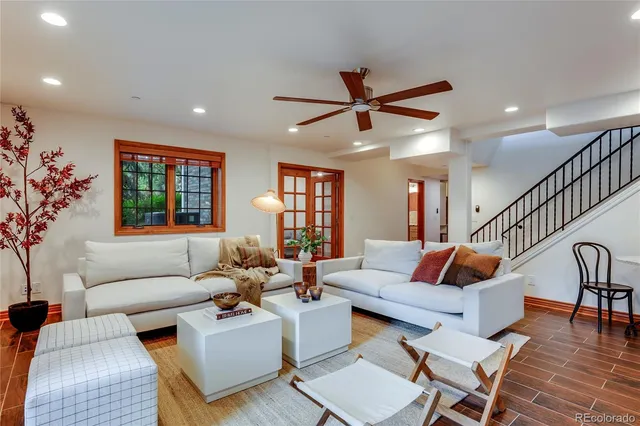a living room with furniture two window and a dining table
