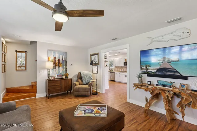 a kitchen with stainless steel appliances granite countertop a dining table chairs and white cabinets