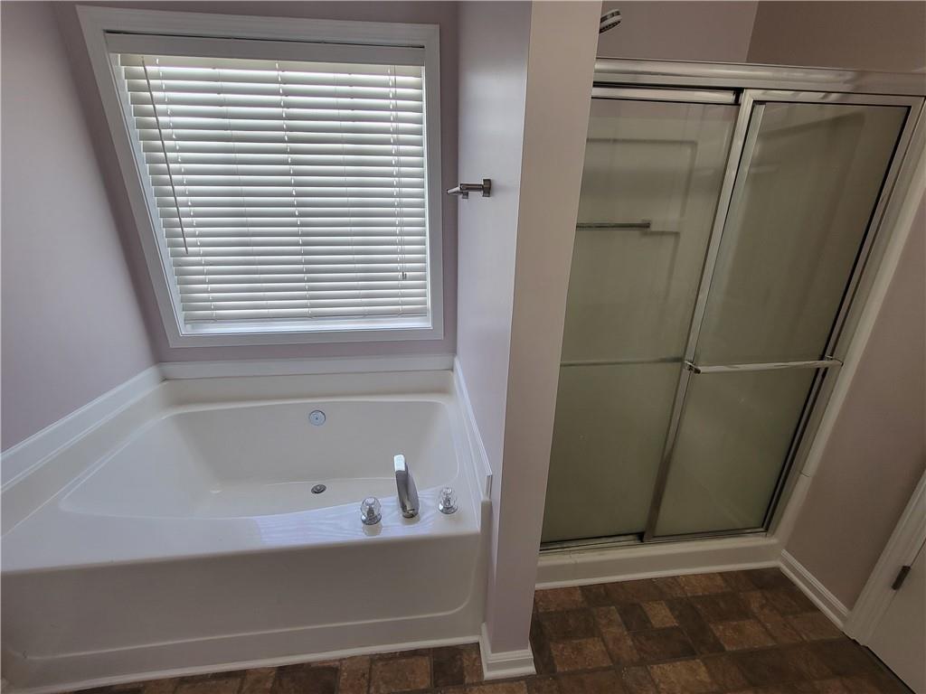 2213 Carlton Chase Road Dacula, GA 30019 - Photo 16 of 30 a bathroom with a bathtub and a shower