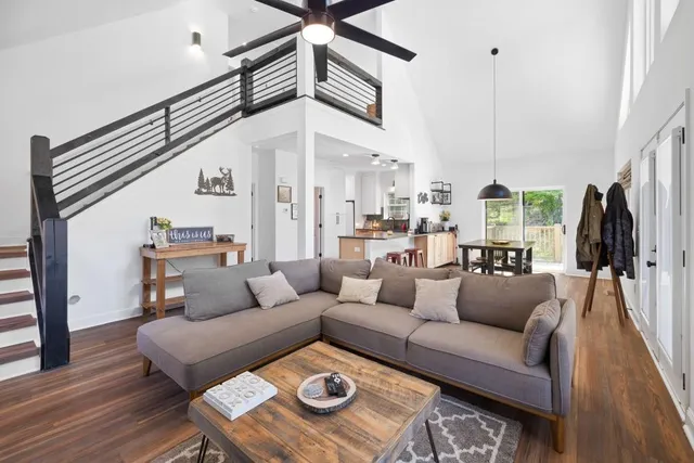 a dining room with stainless steel appliances granite countertop a stove a kitchen island a dining table and chairs with wooden floor