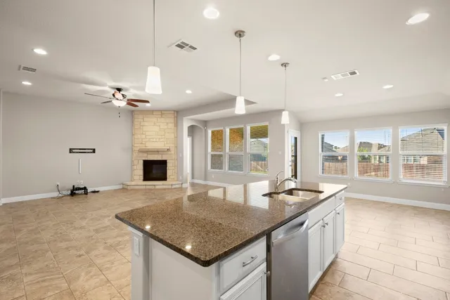 a kitchen with granite countertop a sink and a stove