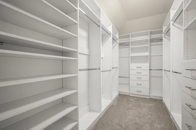 a view of walk in closet with empty racks