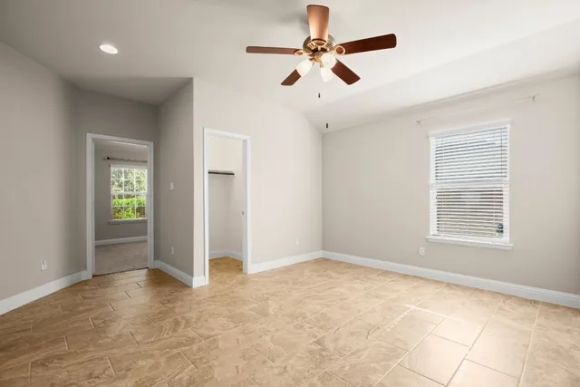 an empty room with a window and a fan