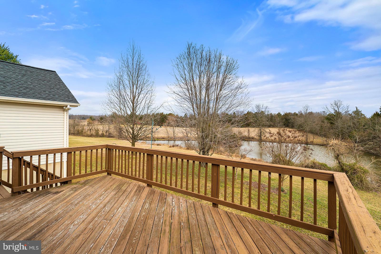 large deck with stairs over looking pond