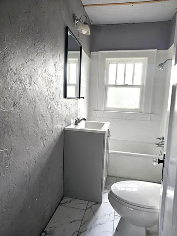 a bathroom with a sink toilet and window