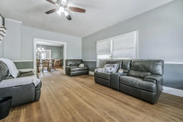 a living room with furniture and wooden floor