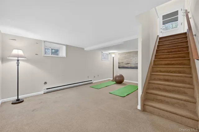 a view of an empty room with wooden floor and windows