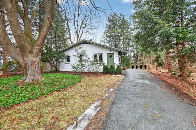 a view of a house with a yard and large tree