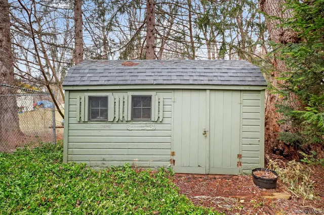 a view of a yard with plants and large trees