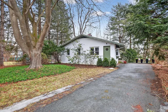 a view of a house with a yard and large trees