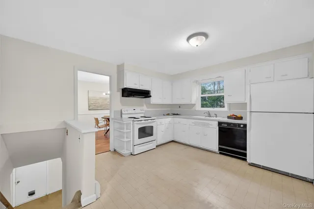 a kitchen with white cabinets and white appliances