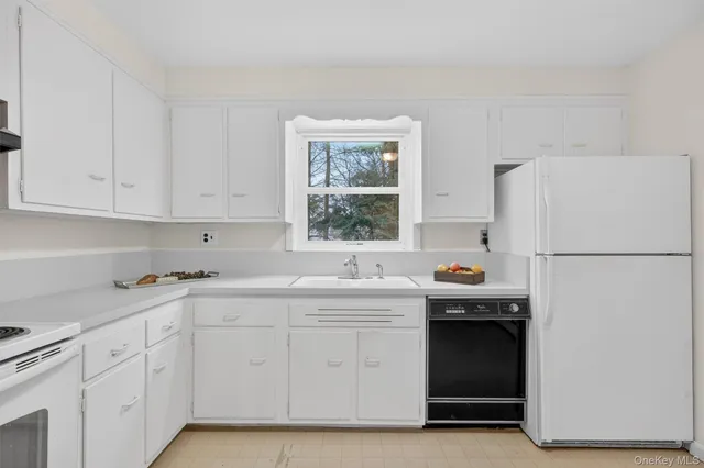 a kitchen with white cabinets and white appliances
