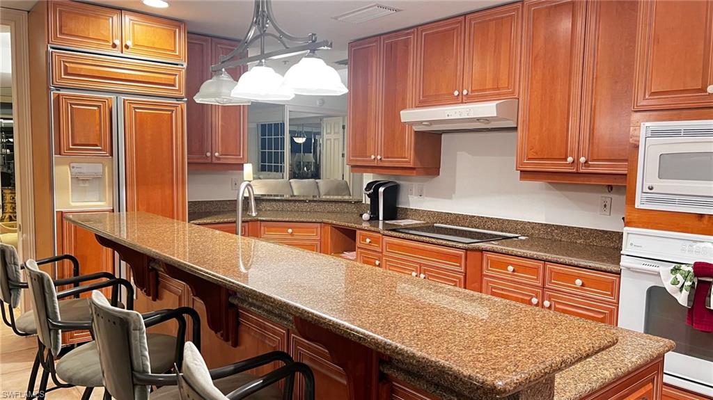 391 4th Street South, Unit 401 Naples, FL 34102 - Photo 11 of 31 a kitchen with granite countertop a sink and cabinets