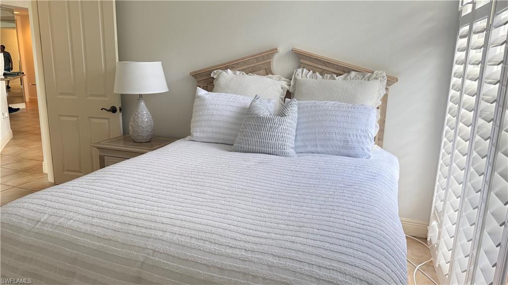 391 4th Street South, Unit 401 Naples, FL 34102 - Photo 22 of 31 a bedroom with a bed and a lamp