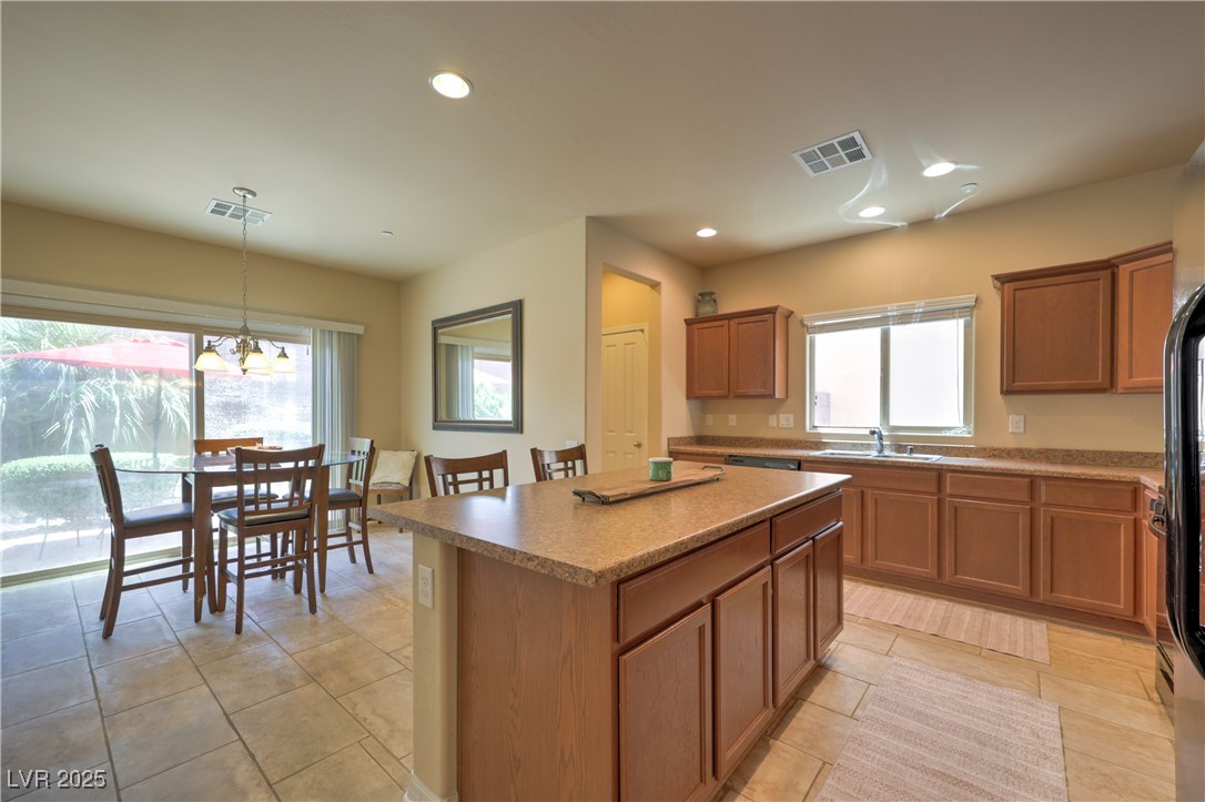 2373 Rue Royale Street Henderson, NV 89044 - Photo 11 of 29 Kitchen with a center island, a sink, brown cabine