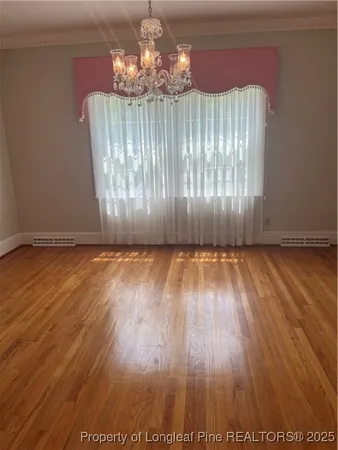 a view of a room with wooden floor chandelier and entryway