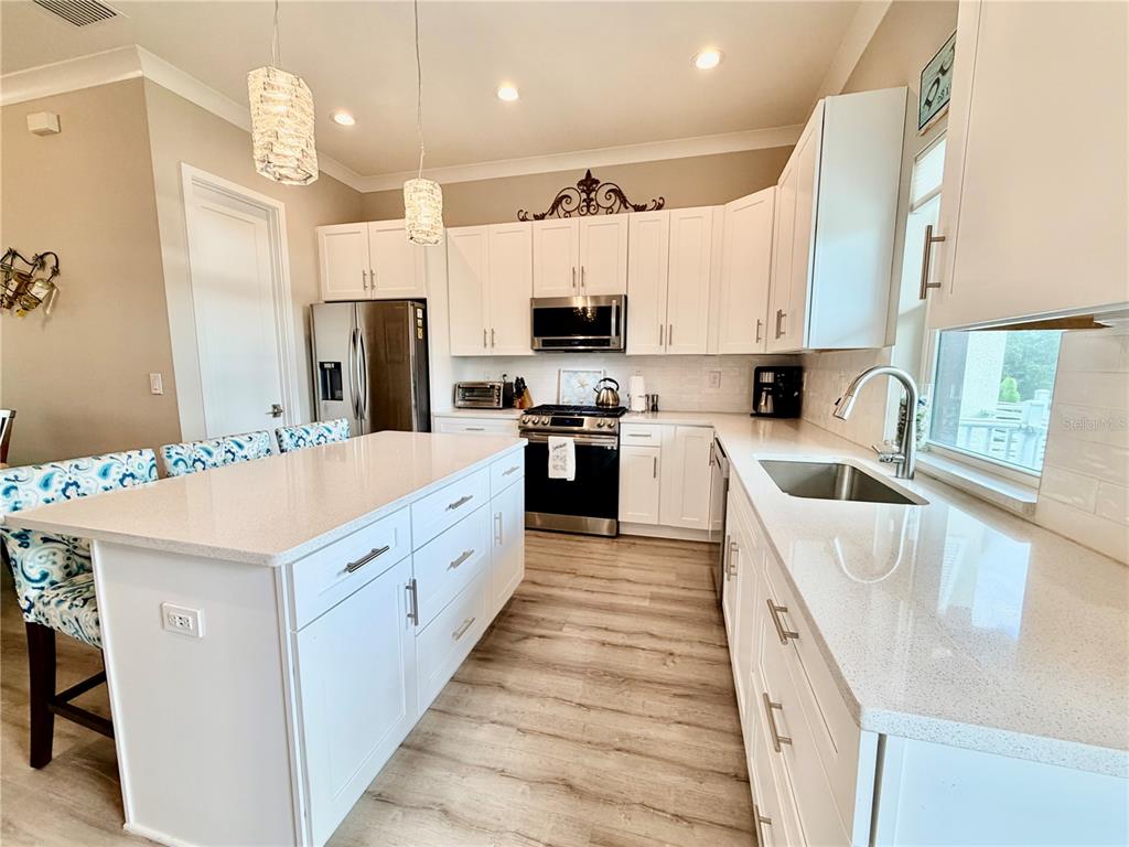 946 Highland Avenue Dunedin, FL 34698 - Photo 18 of 45 a large kitchen with stainless steel appliances kitchen island granite countertop a sink and white cabinets