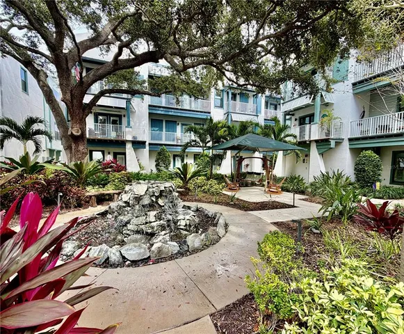 a view of a patio with table and chairs potted plants and palm trees