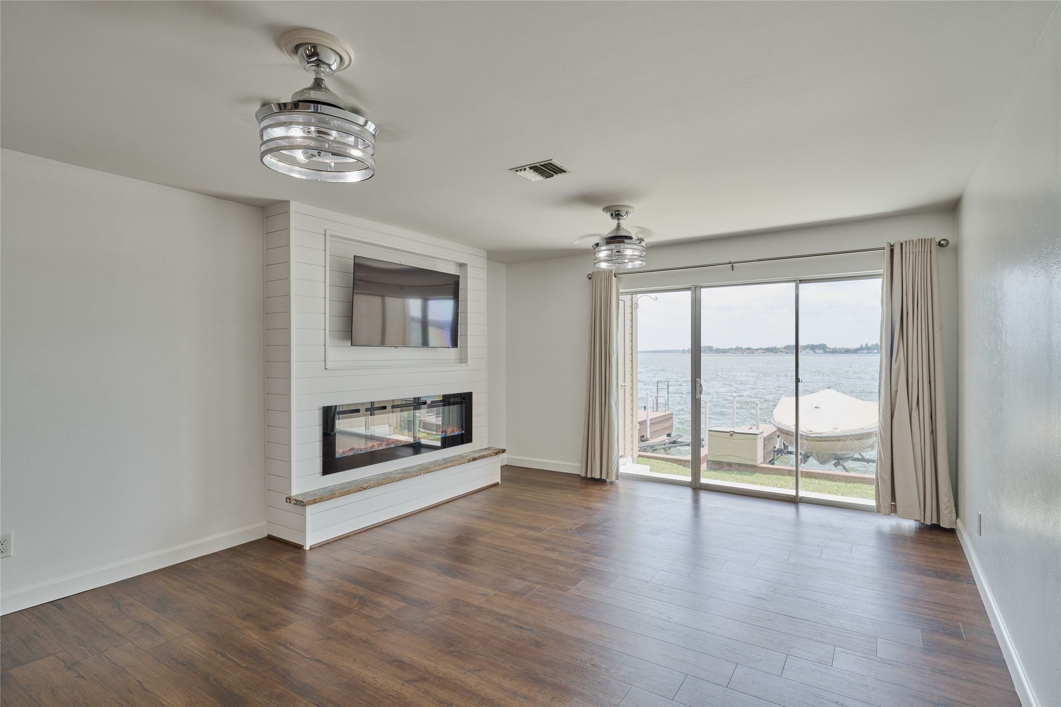 801 River Road, Unit E111 Montgomery, TX 77356 - Photo 3 of 26 Spacious living room boasts an electric fireplace and both the TV in living room and in the kitchen will remain. Great water views from inside too!