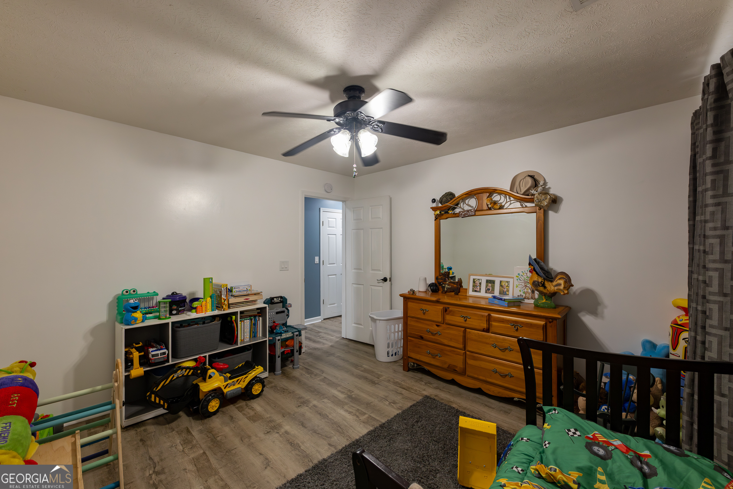 647 Pine Valley Road Meansville, GA 30256 - Photo 15 of 92 a living room with baby crib furniture and a wooden floor