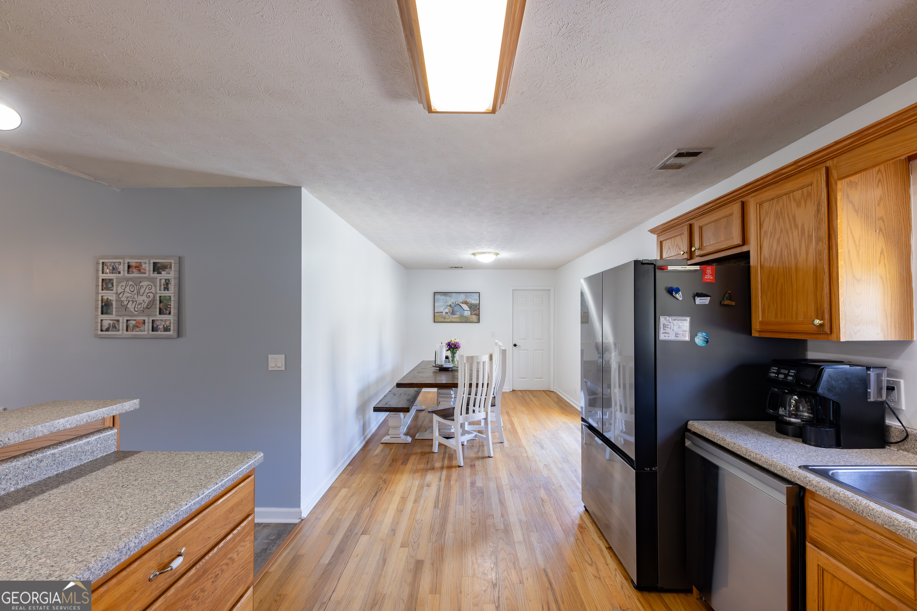 647 Pine Valley Road Meansville, GA 30256 - Photo 10 of 92 a kitchen with stainless steel appliances a refrigerator a sink dishwasher and wooden cabinets with wooden floor