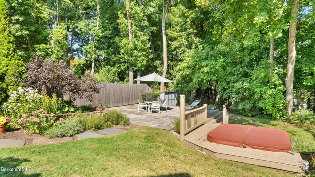 a view of a white house with large windows and a table and chairs