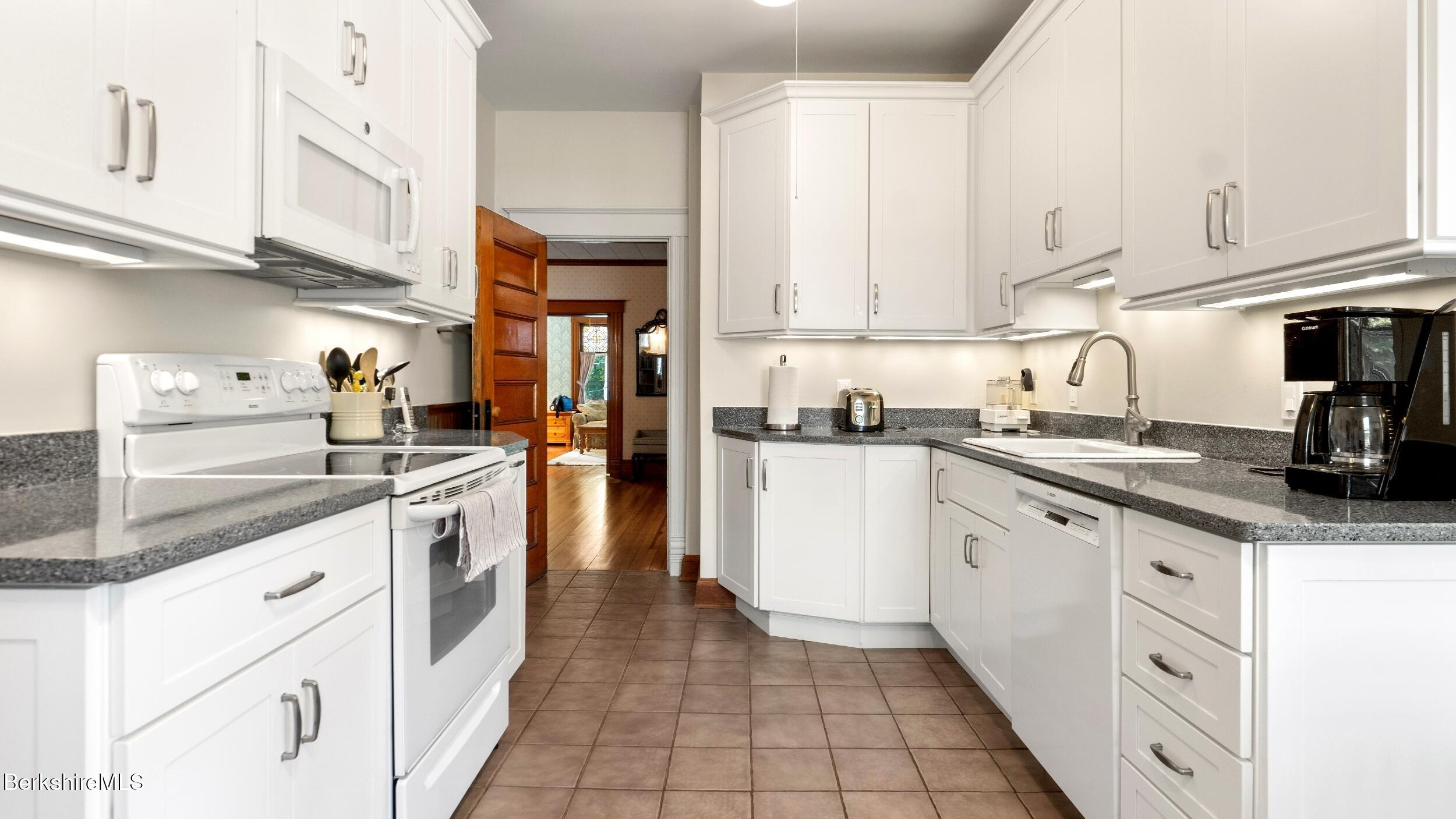 211 Cottage Street Great Barrington, MA 01236 - Photo 7 of 53 a kitchen with granite countertop a sink a stove and cabinets