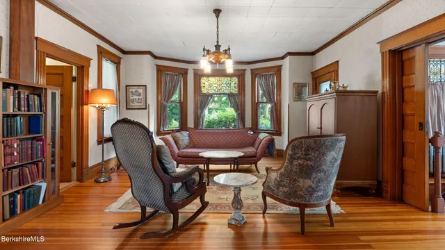 a dining room with furniture a book shelves and wooden floor