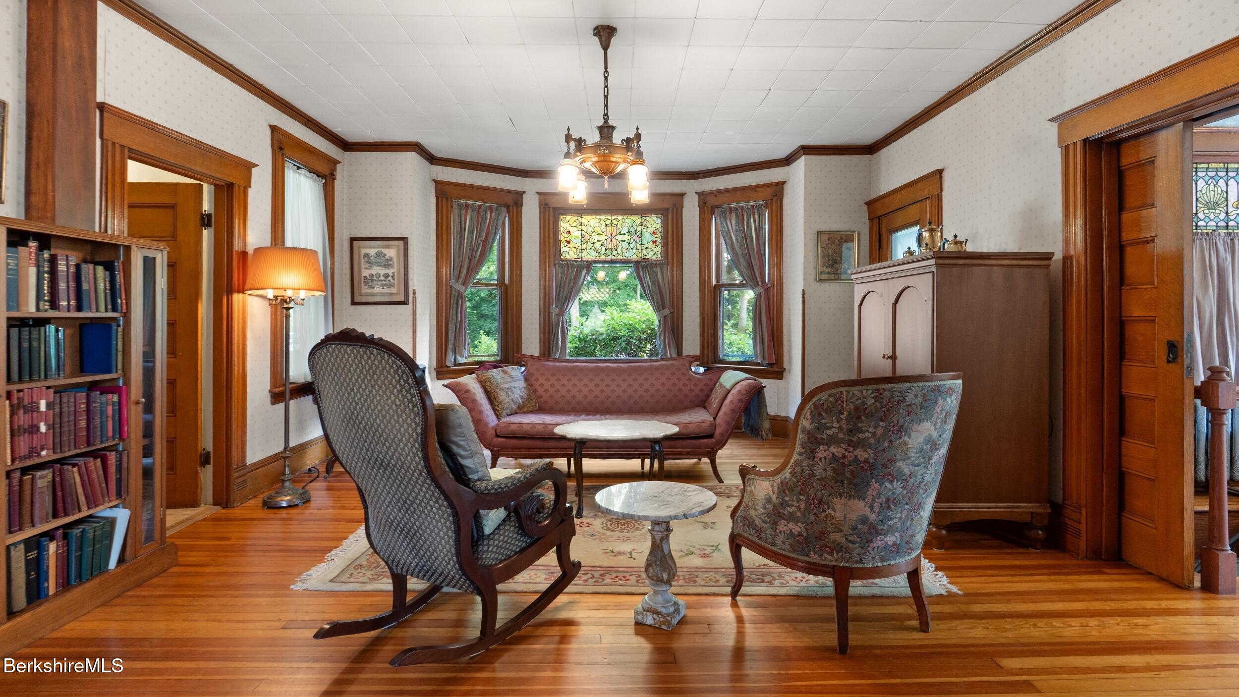 211 Cottage Street Great Barrington, MA 01236 - Photo 9 of 53 a dining room with furniture a book shelves and wooden floor