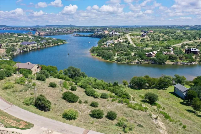 an aerial view of a house with a yard and lake view