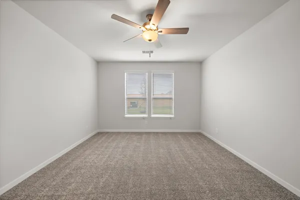 an empty room with a window and a ceiling fan