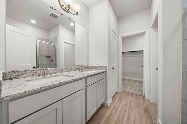 a bathroom with a granite countertop sink a mirror and a shower