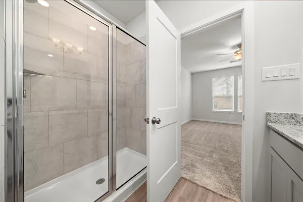 a bathroom with a granite countertop bathtub shower sink and mirror