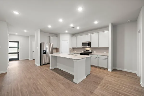 a kitchen with white cabinets and stainless steel appliances