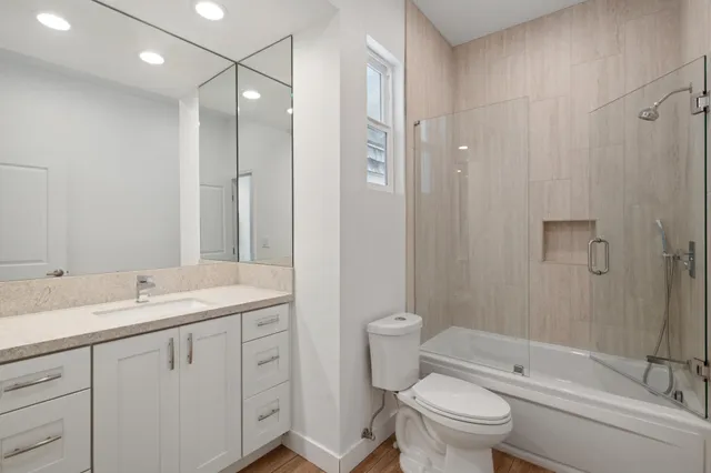 a bathroom with a sink a toilet and shower