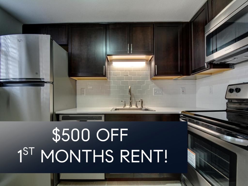 2500 Burleson Road, Unit 609 Austin, TX 78741 - Photo 2 of 23 A contemporary kitchen features dark cabinetry, bright subway tile, and modern stainless steel appliances.