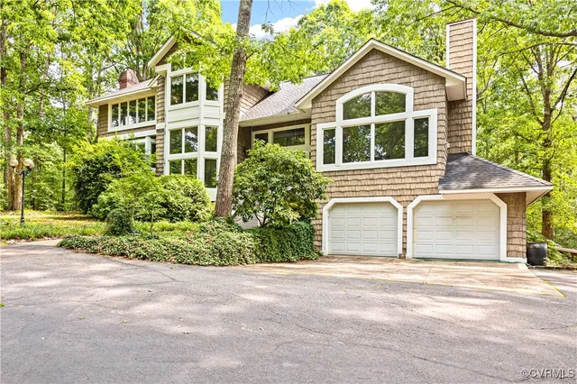 a view of a yard in front of a house with large windows