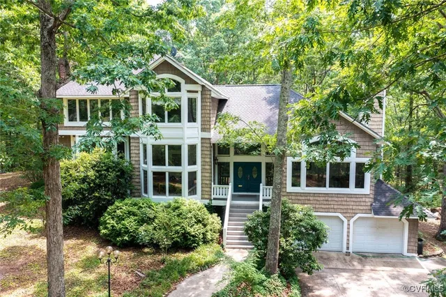 a front view of a house with a yard and potted plants