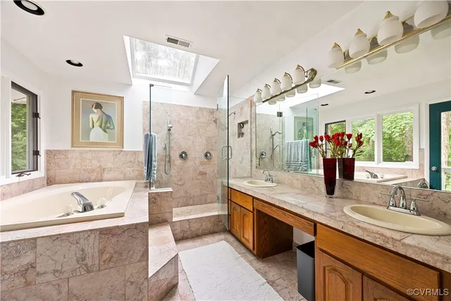 a spacious bathroom with a tub sink and mirror