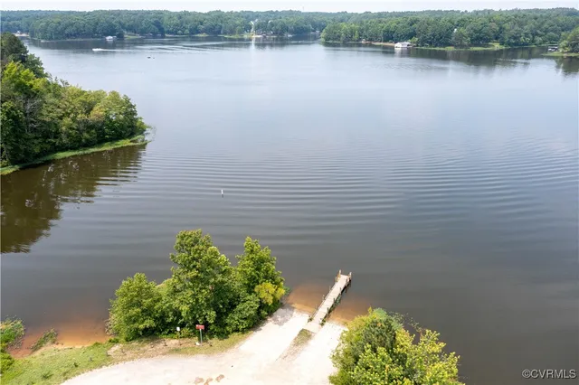 an aerial view of a house with a yard and lake view