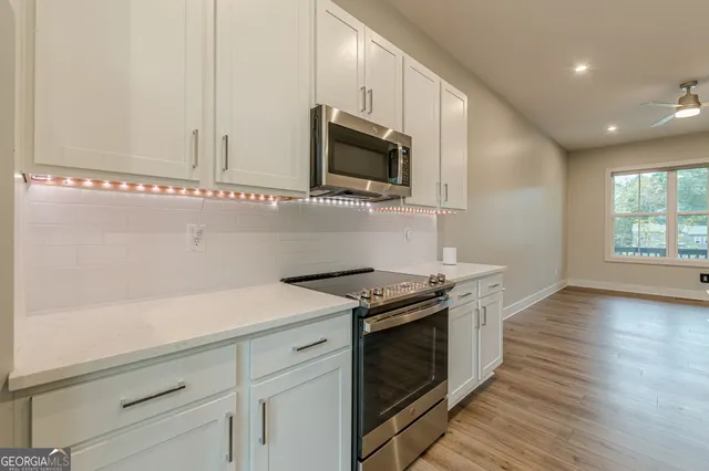a kitchen with stainless steel appliances white cabinets and a granite counter tops