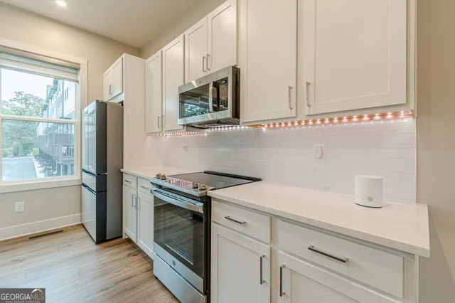 a view of a kitchen with a sink and wooden floor
