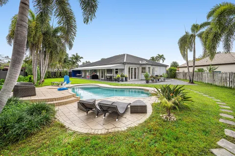 a view of a house with swimming pool and sitting area