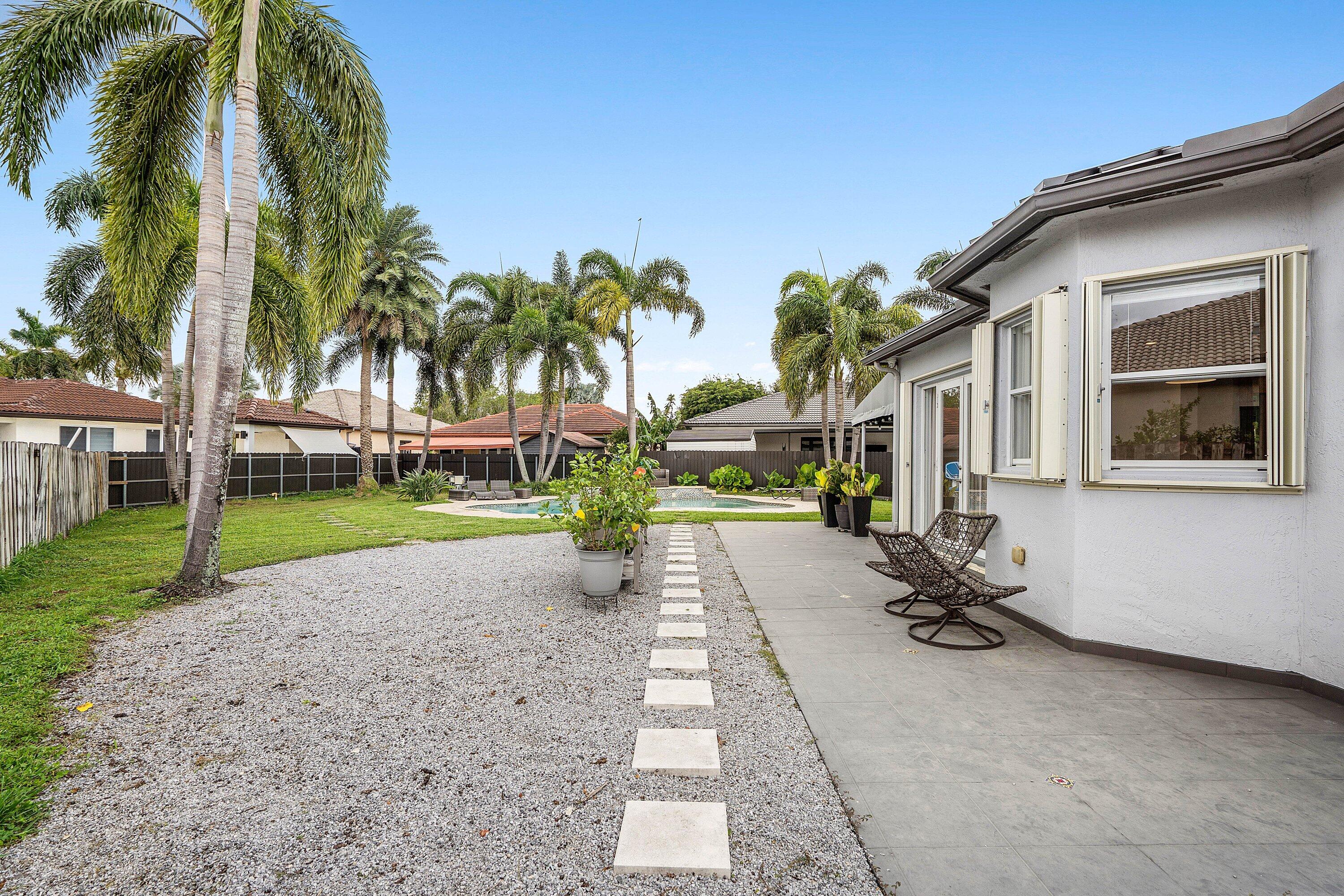 16852 Northwest 88th Path Miami Lakes, FL 33018 - Photo 30 of 34 a front view of a house with a garden and patio